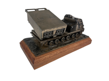 A bronze model of a military tank on a base, a multi launch rocket system featuring detailed tracks, a cabin, and a raised missile launcher attached to the rear.