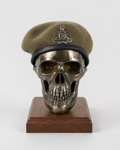 Cold cast bronze skull displaying a military beret on wooden base